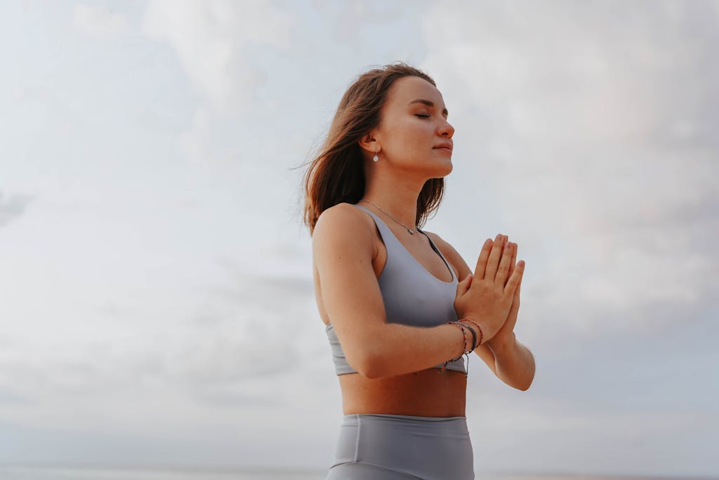 Young woman practicing yoga meditation outdoors, embodying wellness and relaxation.